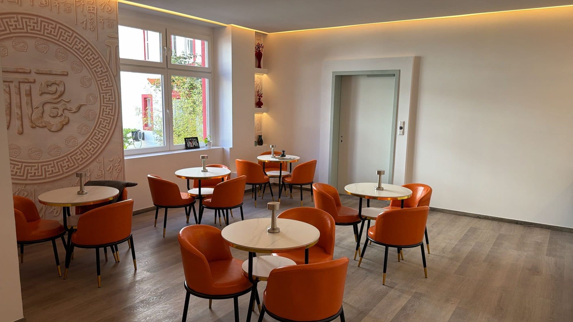 Frühstücksraum mit Fensterfront und Sitzgruppen