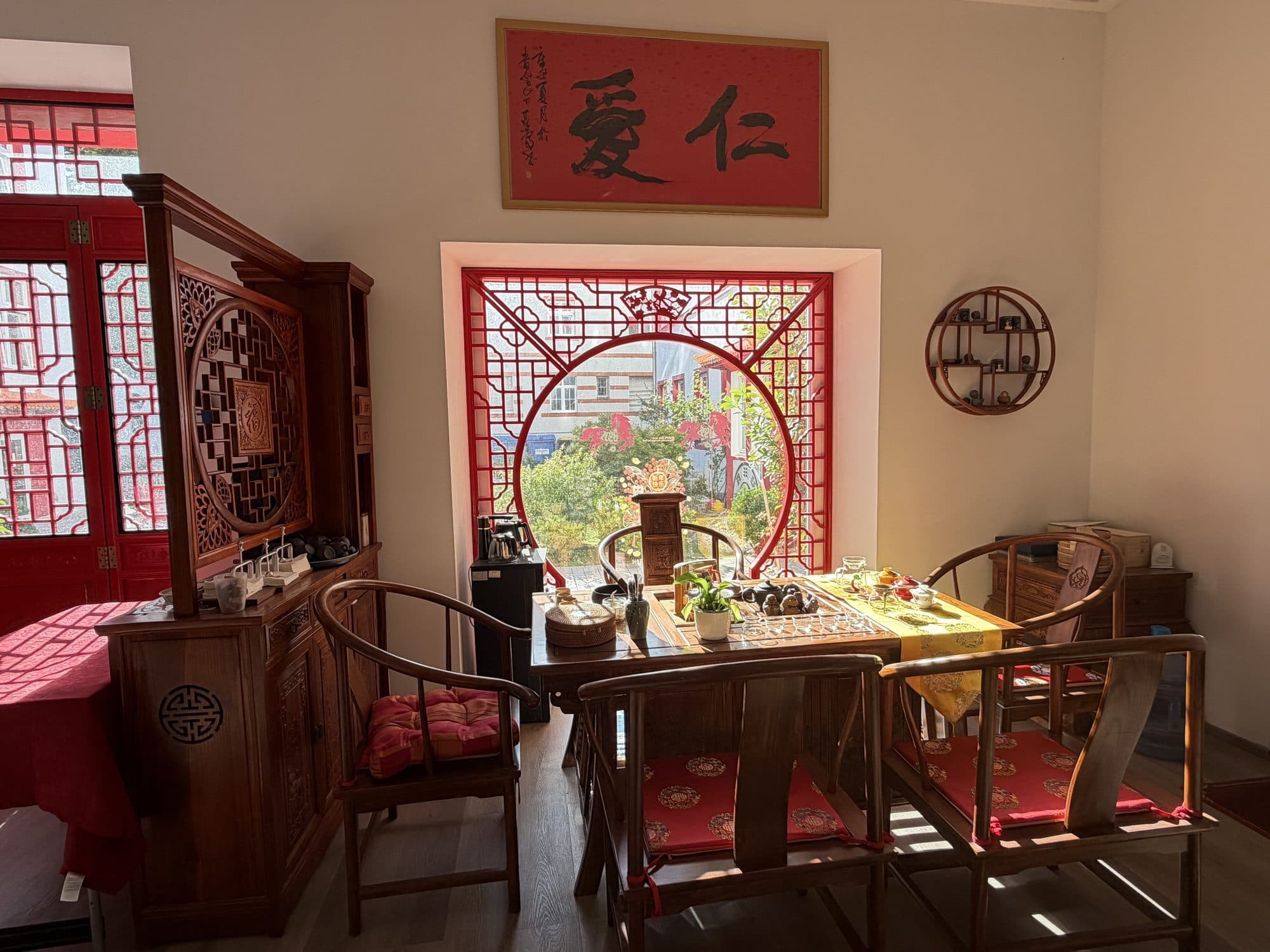 Teehaus mit chinesischen Holzmöbeln und Kalligrafie an der Wand