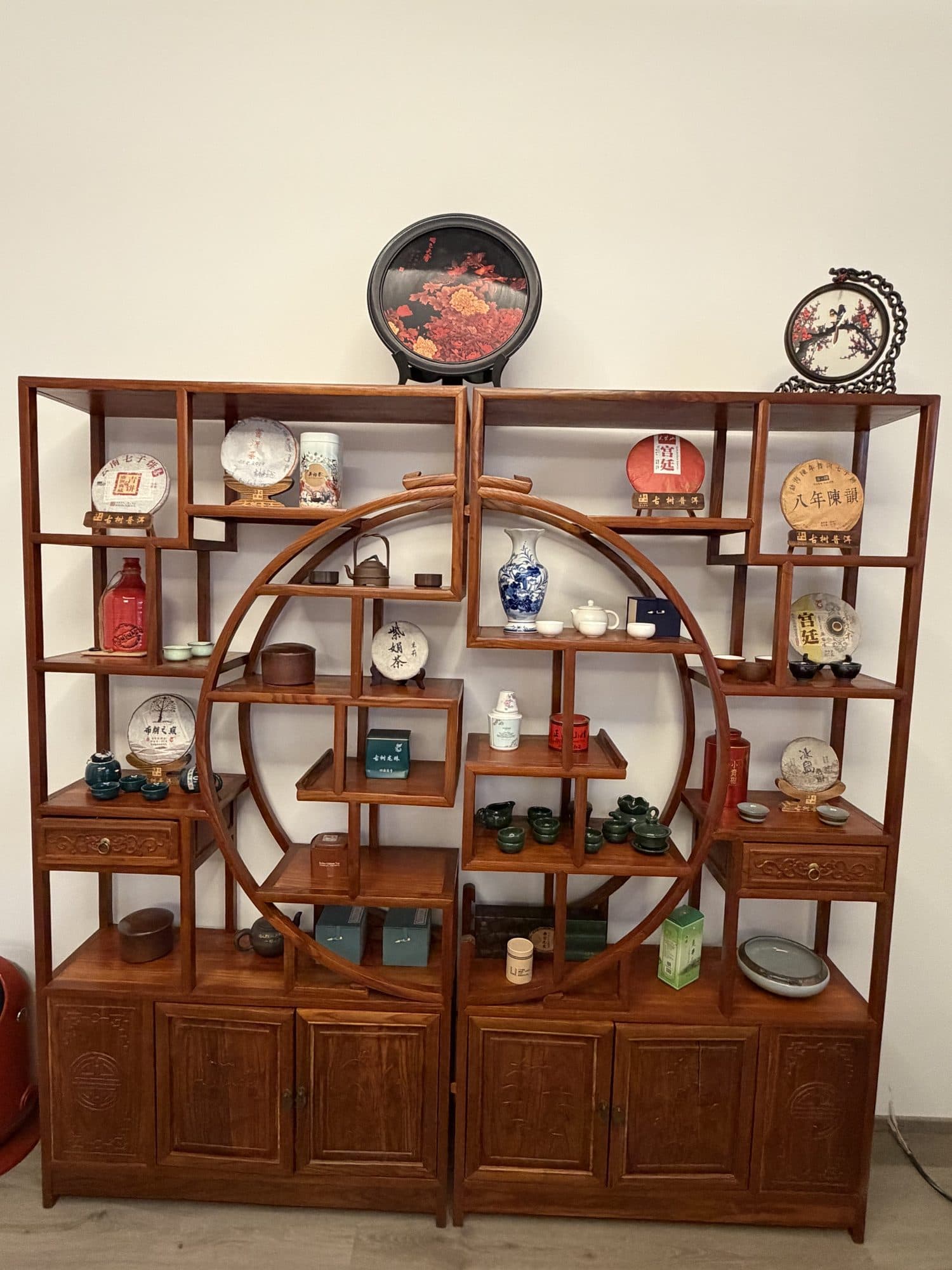 Regal aus Rosenholz mit gepressten Pu-Erh-Fladen, Teedosen, Kannen und Bechern
